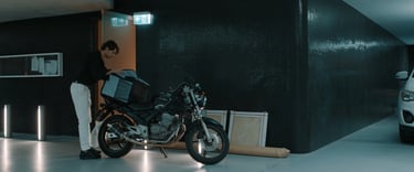 a man standing next to a motorcycle in a garage
