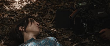 a woman laying on the ground with a camera and a camera