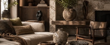 Rustic modern living room featuring a travertine coffee table, curved sofa, and earthy stone wall decor.