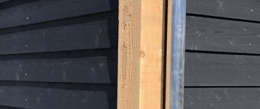 outside wood sidings painted with a black matte color