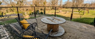 Terrasse suspendu surplombant les parcelles maraîchères et le jardin du gite des ramières à la ferme gourmande