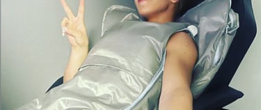 A woman relaxes in a  infrared bodywrap sauna blanket for detox and wellness therapy.