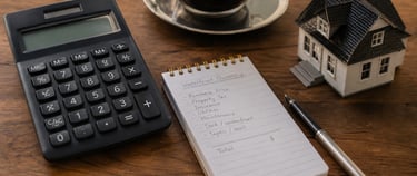Home model with calculator and notes on desk.