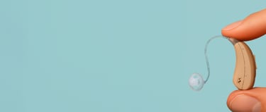 aparelho auditivo do tipo ric sendo segurado na ponta dos dedos