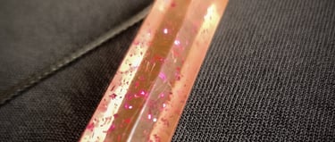 a pink and gold necklace with a pink and pink glitter