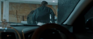 a man in a black jacket is standing in front of a windscreen