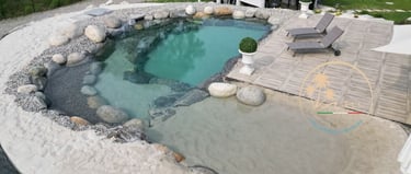 piscina con spiaggia bianca e zona solarium