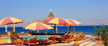 Zoetwaterzwembad en traditionele strand-Arisha met open parasols aan de Rode Zee bij Bedouin Star