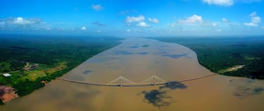 a bridge spanning a river with a bridge in the background