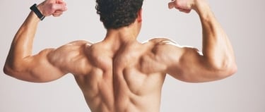Muscular man flexing his back and arm muscles during a fitness workout bodybuilder pose.