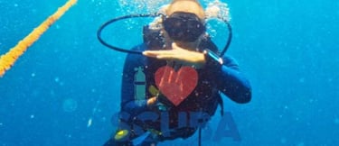 Scuba Duka diving center gift voucher featuring a diver underwater in Diani Beach Kenya with SSI logo and QR code.