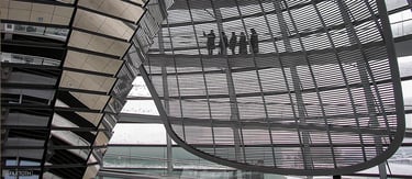 Soft winter daylight filters through glass panels as visitors ascend the spiral ramp inside the Reichstag dome.