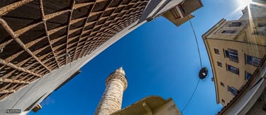 The Ahmet Ağa Minaret rises above Chania’s narrow streets as daylight filters through the historic lane.