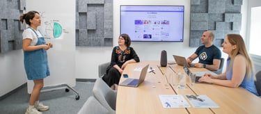 a woman in a blue dress standing in front of a large screen
