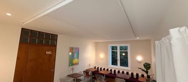 Intérieur de café moderne avec un grand panneau de plafond acoustique blanc et des meubles vintage