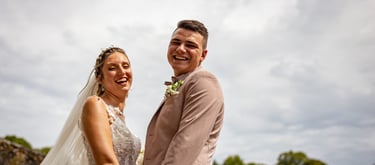 a bride and groom standing in front of a tree