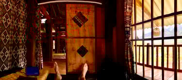 a person's feet on a bed in a homestay
