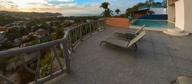 a pool with lounge chairs and a view of the ocean