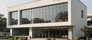 A modern community resource center building with large glass windows and clean lines, South Asian / Indian architectural motifs, surrounded by well-kept urban greenery.