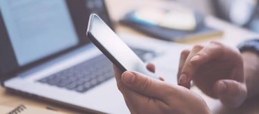 Pessoa pesquisando negócio local no celular antes de tomar decisão de compra
