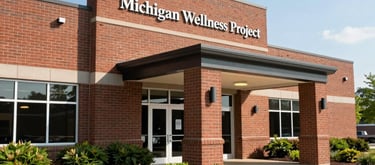 The exterior of the Michigan Wellness Project building in Okemos, Michigan. A professional and welcoming brick office entrance surrounded by neatly landscaped native Michigan greenery. Bright, clear sky. North American / Michigan US.