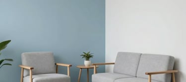 A minimalist consultation room with soft blue and white colors, light wood furniture, and a tranquil atmosphere suitable for psychological therapy. Hispanic architectural details.