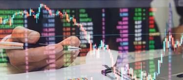 Stock market trader analyzing financial data and candlestick charts for investment trends.