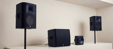 Clean, architectural shot of a minimalist showroom in South America displaying high-end line array speakers and professional lighting gear, elegant navy and off-white color palette.