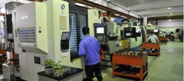 Operators working at CNC milling machines in a modern industrial manufacturing facility.