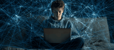 a man sitting on a bed with a laptop computer