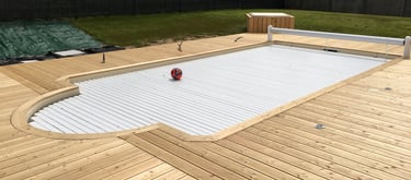 Piscine extérieure entourée d'une terrasse en bois conçue par la menuiserie Glohr