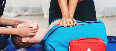 Two people practising CPR on a dummy in First Aid training