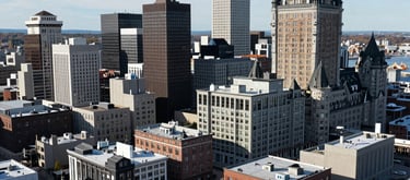 An aerial view of the Saint John, Canada city skyline during a bright day, representing the local economic driver and the home of the Ministry of Entrepreneurs.