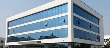 Exterior shot of a contemporary industrial building in Pakistan, clean architectural lines, corporate blue glass windows, under a clear sky, surrounded by well-kept green space.