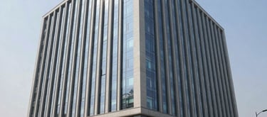 Modern office building exterior in an Indian tech park, sunny day, professional setting.
