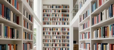 A bright, airy home library in South America with high ceilings, white walls, and floor-to-ceiling bookshelves filled with books. Clean, minimalist interior design.
