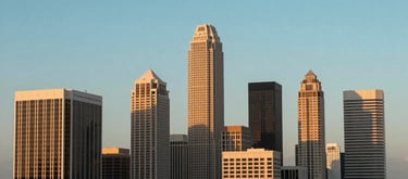 A crisp, professional wide shot of a Florida business district skyline at sunset, emphasizing a clean, prosperous urban environment. Tones of turquoise and navy in the sky.