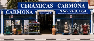 Ceramicas Carmona storefront in Spain showcasing decorative garden statues and ceramic pottery.