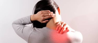 Person holding back of neck in pain due to muscle stiffness.