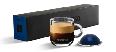 xícara de café com cápsula e caixas de cápsulas nespresso