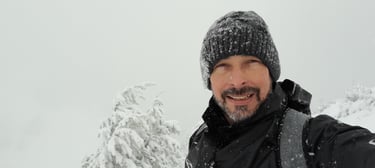 a man in a black jacket and a hat on a snowy day