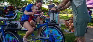 Parent and child mixing a smoothie on our blender bikes!