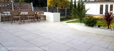 Modern chic raised porcelain patio with white rendered walls and planters