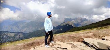 Clouds casting playful shadows on Himalayan mountains, Uttarakhand, serene alpine landscape.