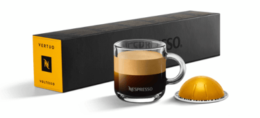 xícara de café com cápsula e caixas de cápsulas nespresso