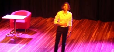 a woman standing on a stage with a chair and a chair