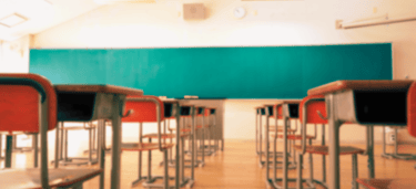 uma sala de aula com um quadro negro no meio da sala