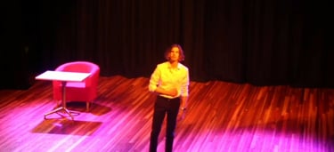 a woman standing on a stage with a chair and a chair