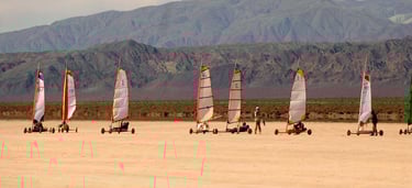 a group of people are sailing on the beach