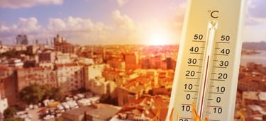 Thermometer showing high temperatures over a sun-drenched city during a summer heatwave.